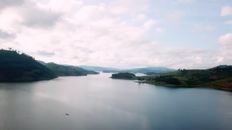 Bird's-Eye-View-Of-Canoe-Sailing-Across-Lake-Bunyonyi-In-Uganda,-East-Africa