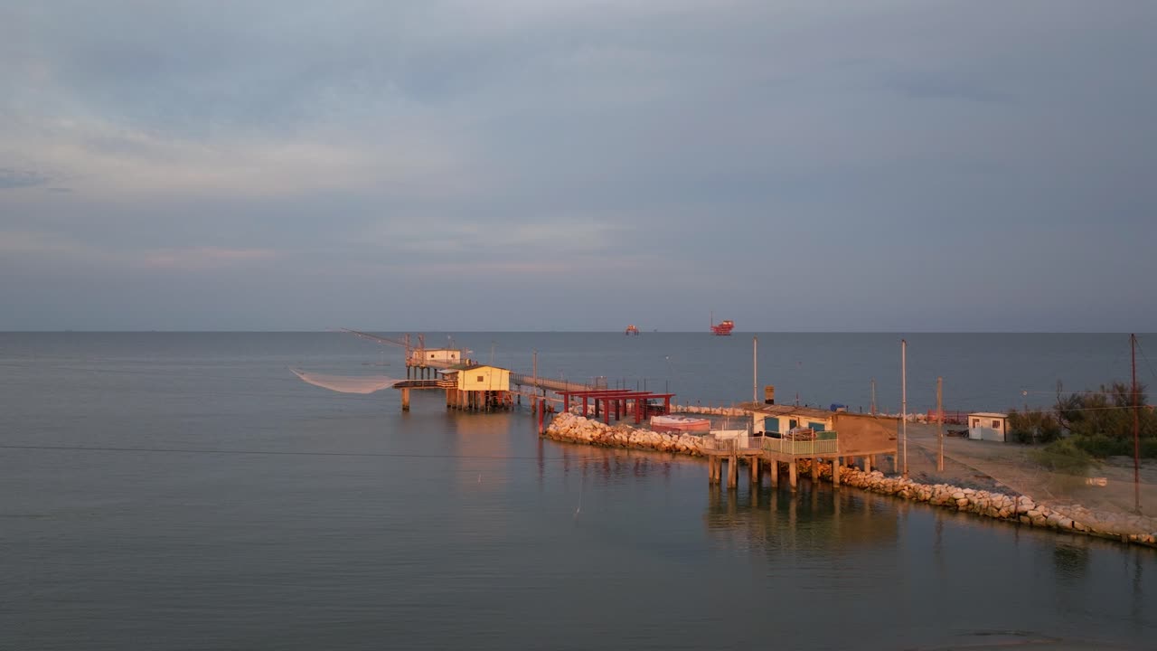 Aerial view of fishing huts on shores of estuary at sunset,italian fishing machine, called "trabucco",Lido di Dante, Ravenna near Comacchio valley-1