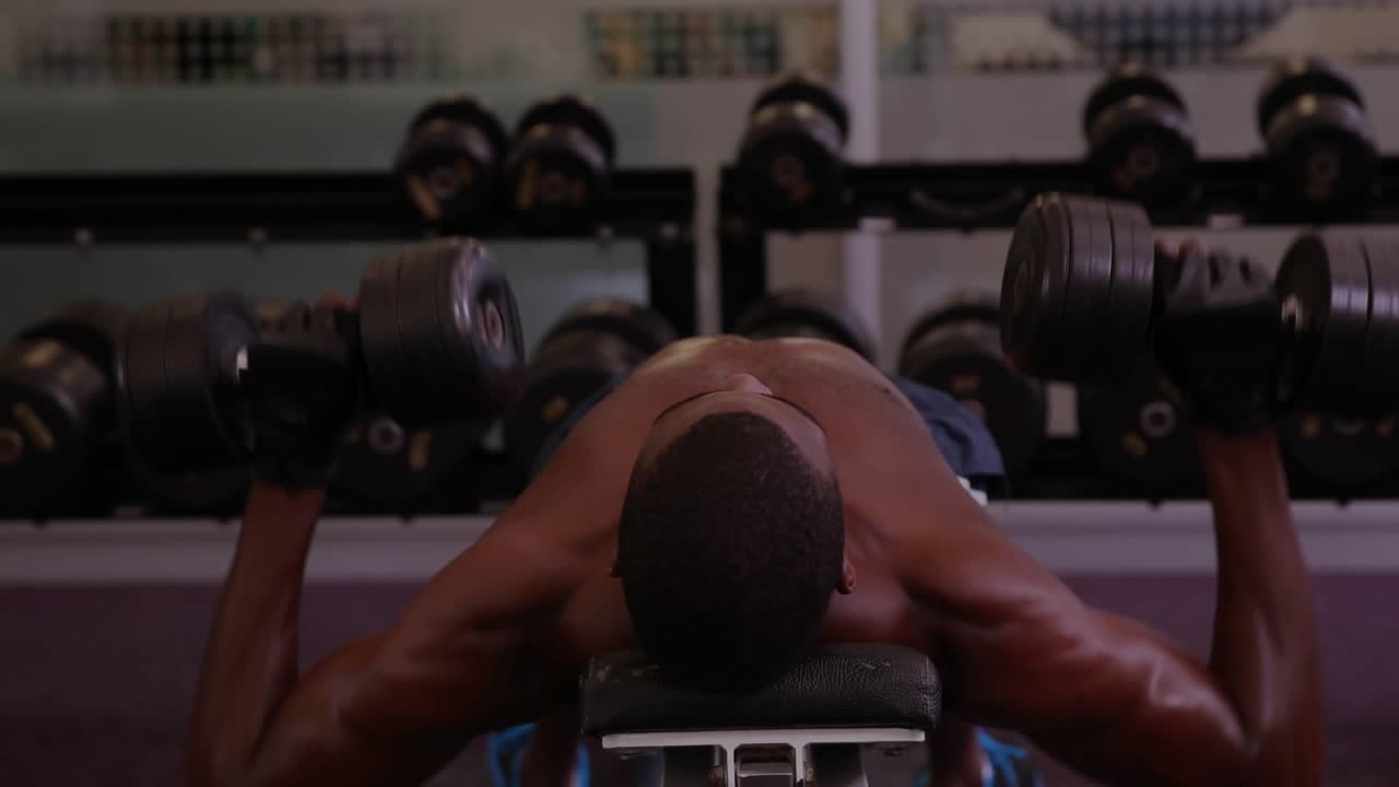 Male lifter starting press on bench, pressing weights for fitness while data charts overlay mirror