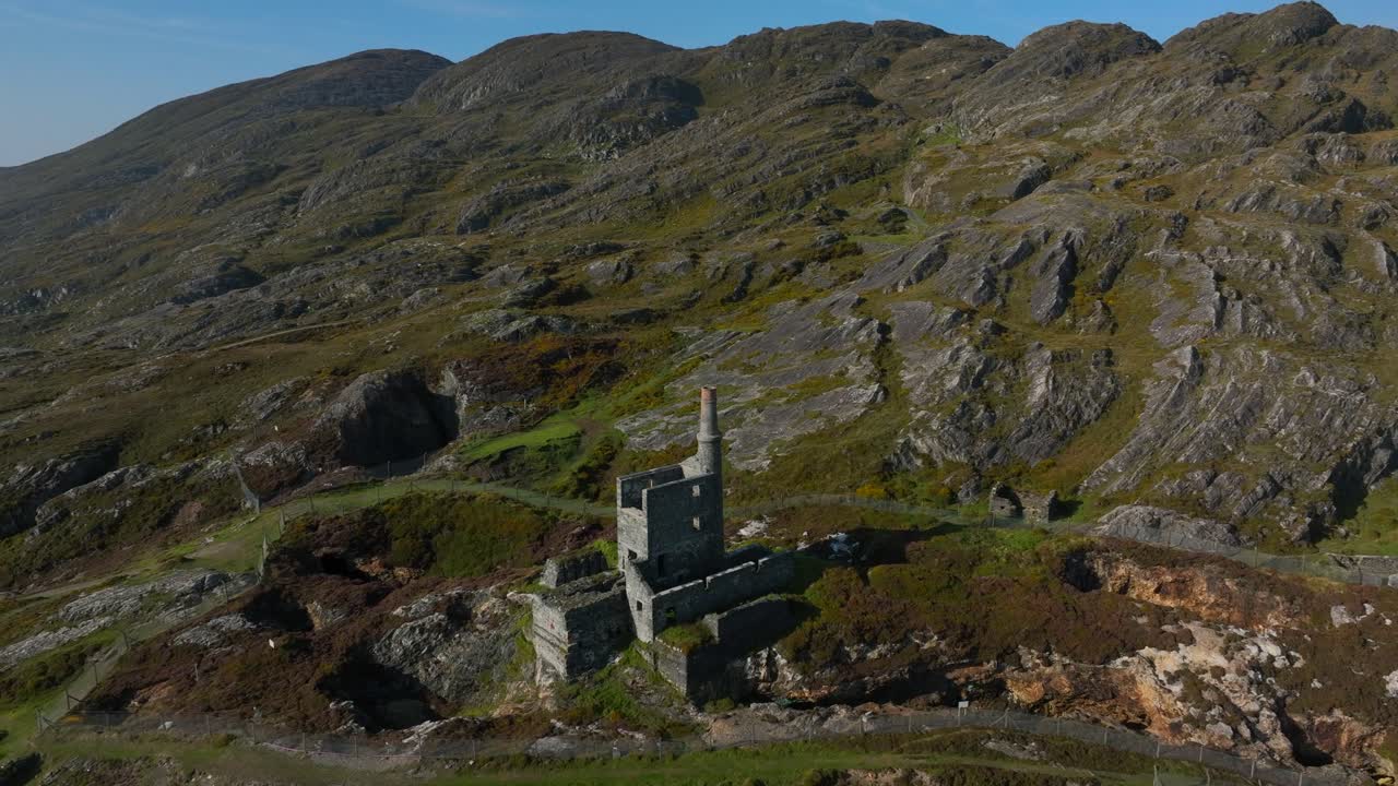 Copper Mine, Allihies, County Cork, Ireland, September 2024. Drone slowly orbits counter clockwise around ruined building on a rocky mountain slope with the North Atlantic Ocean in the background.