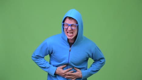 young handsome nerd man having stomach ache
