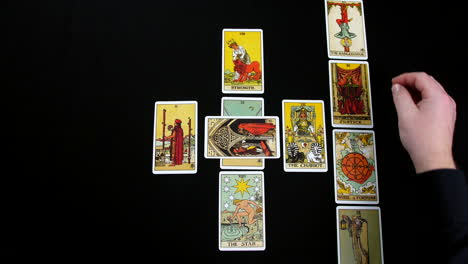 A tarot reader’s hands are laying out a Celtic Cross tarot spread featuring colorful cards with intricate designs. Traditional tarot reading process, focusing on the symbolic placement of the cards