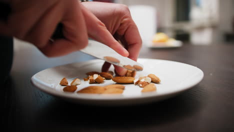 chef's hands divide almonds dried fruit to season desserts