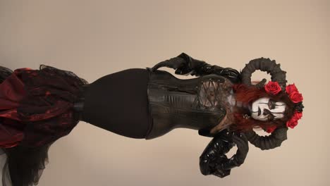 mysterious woman in a devil costume with red roses