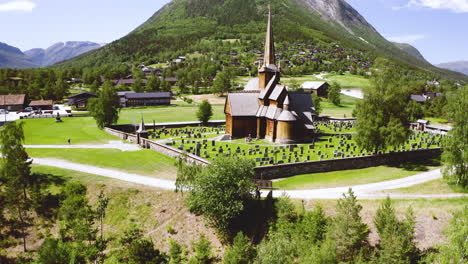 vista esterna della chiesa a doghe di lom circondata da lapidi vicino al villaggio in norvegia