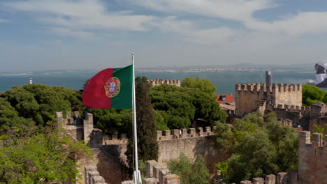 Cerrar-Vista-Aérea-De-Portugal-Y-La-Bandera-De-Lisboa-Ondeando-En-El-Viento-En-La-Cima-Del-Castillo-De-S-Jorge-Lisboa-Castillo-En-La-Cima-De-La-Colina-Con-Vistas-Al-Mar