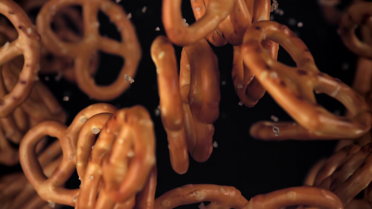 Saltede kringler falder i slowmotion med saltkrystaller.