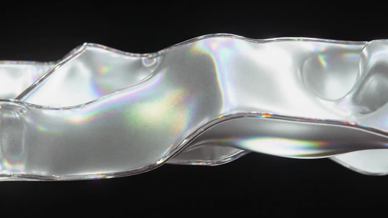 Shifting glassy ribbon forming rolling crests in black studio, off-camera lights creating prisms