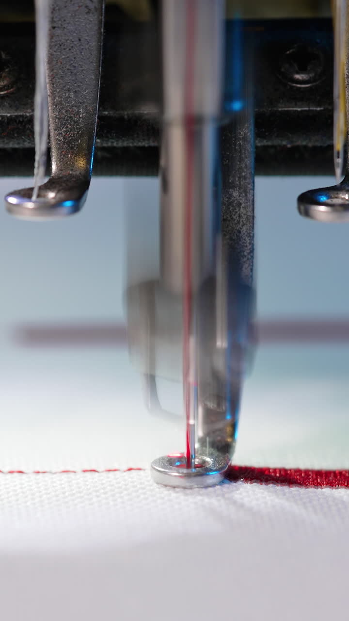 Textile Industry At Garment Manufacturer. Sewing machine embroiders various companies and engravings. Vertical video