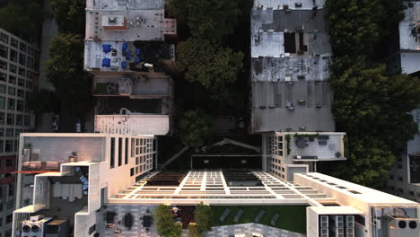 Aerial-view-above-the-rooftop-of-a-sunlit-apartment-building,-golden-hour-in-New-York---birds-eye,-drone-shot