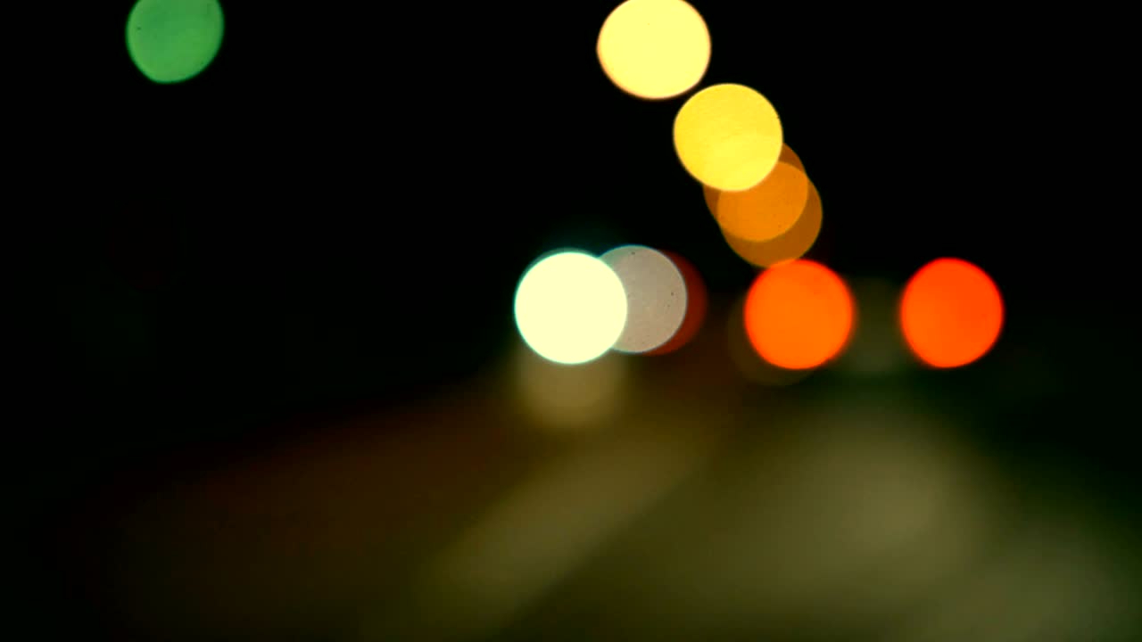 conducir un coche a través de la carretera de la noche, la autopista. luces desenfocadas calle de los ángeles resumen. ciudad fondo borroso. movimientos círculos bokeh de tráfico nocturno.