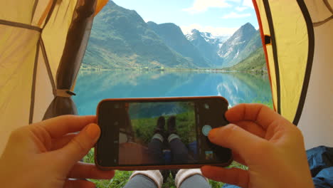 taking a picture of a fjord view from inside a tent