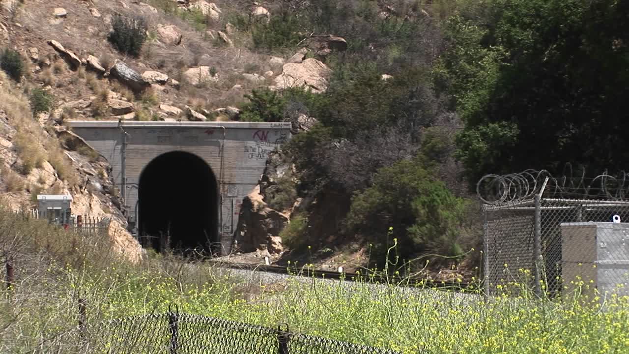 amtrak 여객 열차는 로스 앤젤레스 근처의 언덕 터널을 통과합니다.