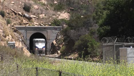 a amtrak passenger train passes through a hillside tunnel near los angeles