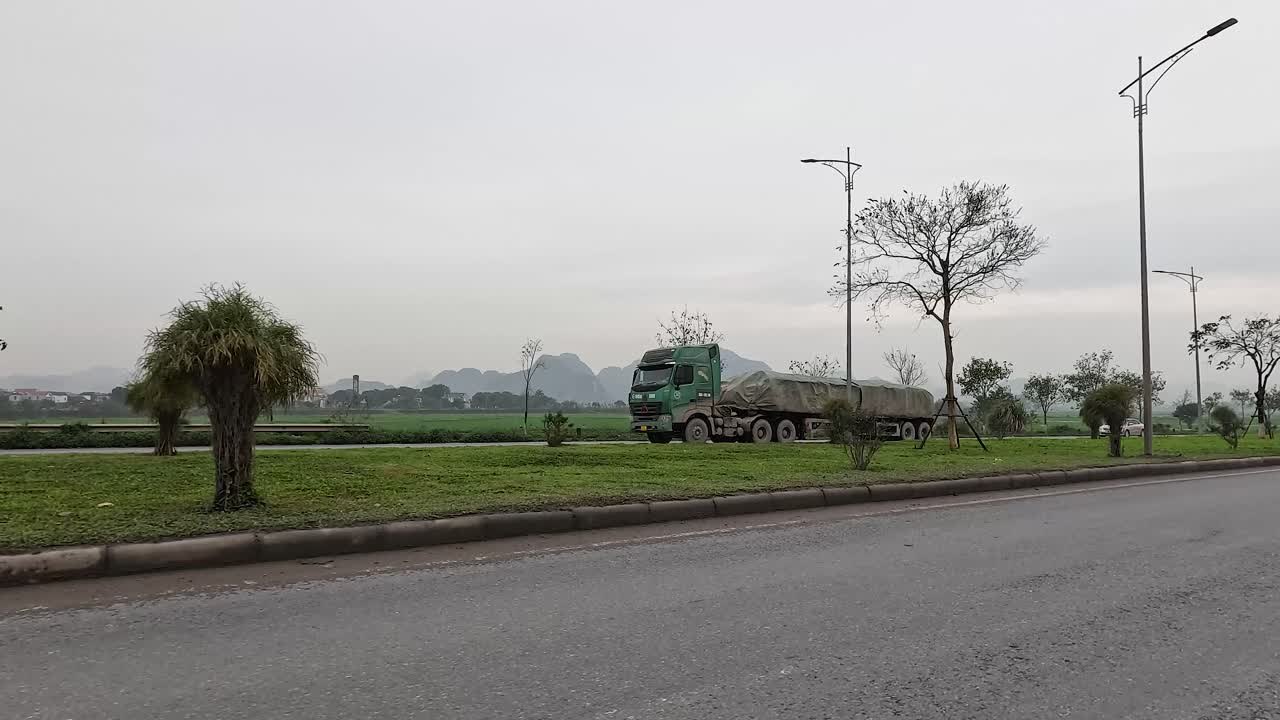 A truck drives along a rural road