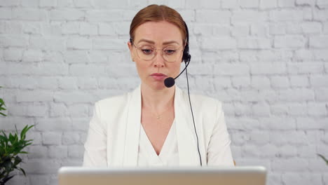 a technical support customer services agent is working in an office and talking on the phone