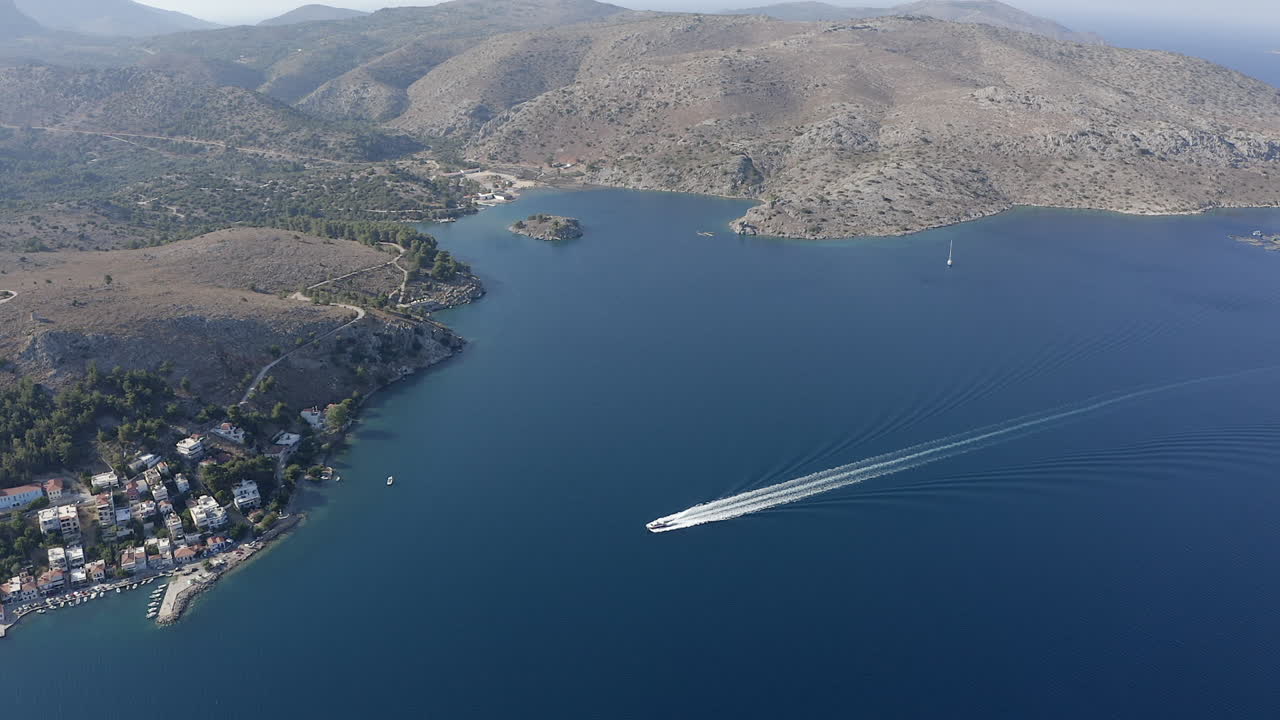 Motorboat has large white wake wave in deep blue Aegean Sea in Greece