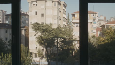 Timelapse-of-Moving-Shadows-of-Buildings-and-Tall-Trees-with-Rising-Sun-over-Blue-Sky-behind-the-Windows-of-Living-Room