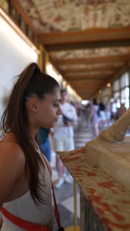 woman observing a sculpture in an art gallery