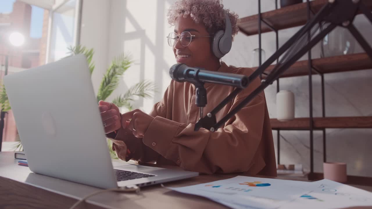 African woman has online fashion stream wears headphones and microphone