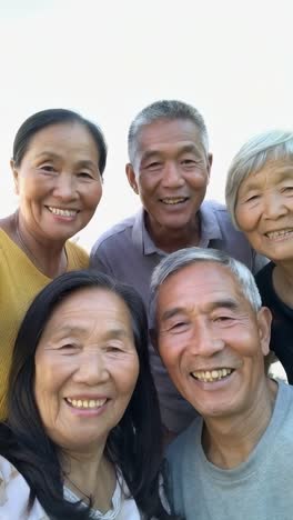 happy asian senior people taking selfie with smartphone device outside