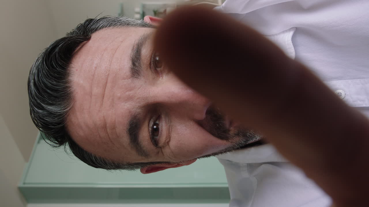 привлекательный белый мужчина проводит видеочат с помощью веб-камеры дома, помахая ребенку, делясь образом жизни, отец наслаждается онлайн-соединением на вертикальном экране