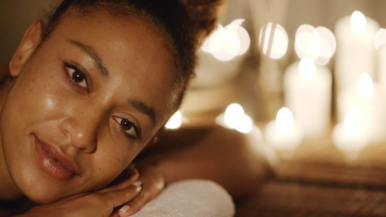 Donna sdraiata in una spa con luci di candele