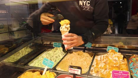 person scooping ice cream into a cone