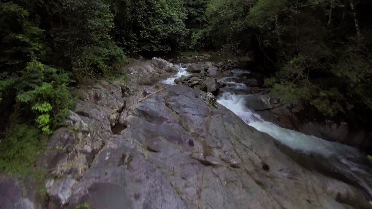 drone empujando un río que fluye en la selva tropical en malasia