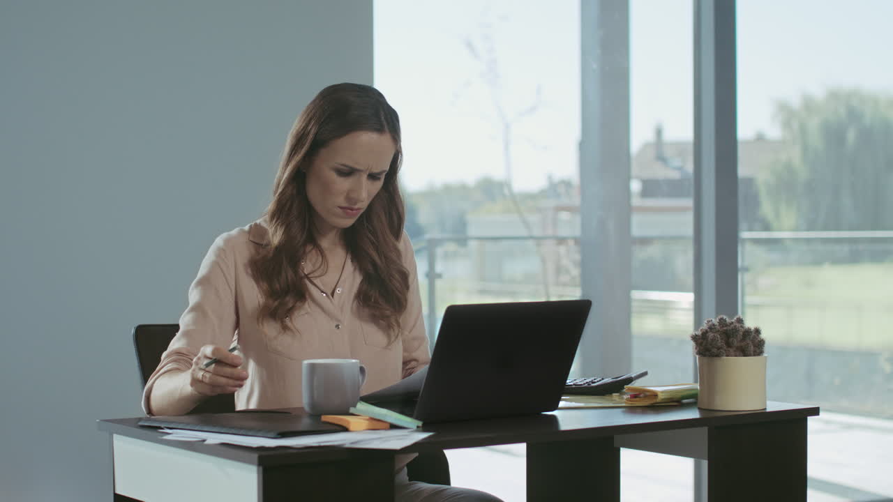 mujer de negocios trabajando en una computadora portátil. mujer molesta comprobando documentos.