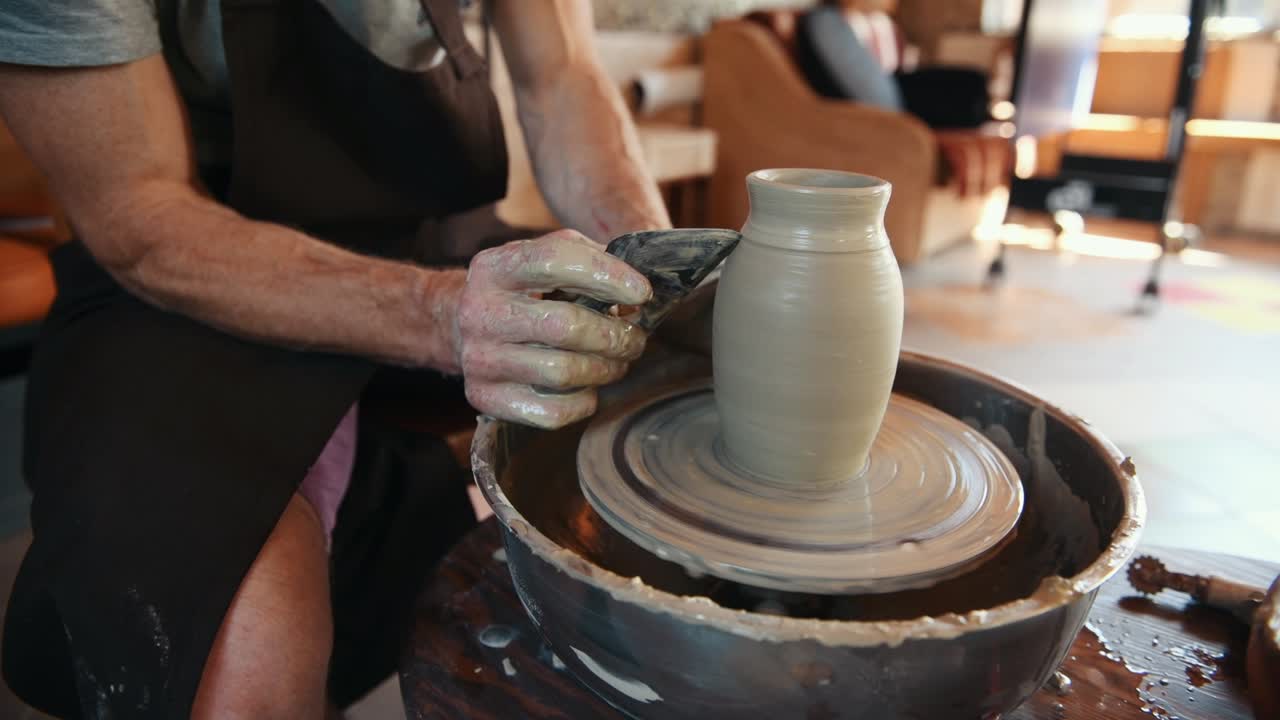 el ceramista utiliza la rueda del alfarero y crea un producto de arcilla hecho a mano
