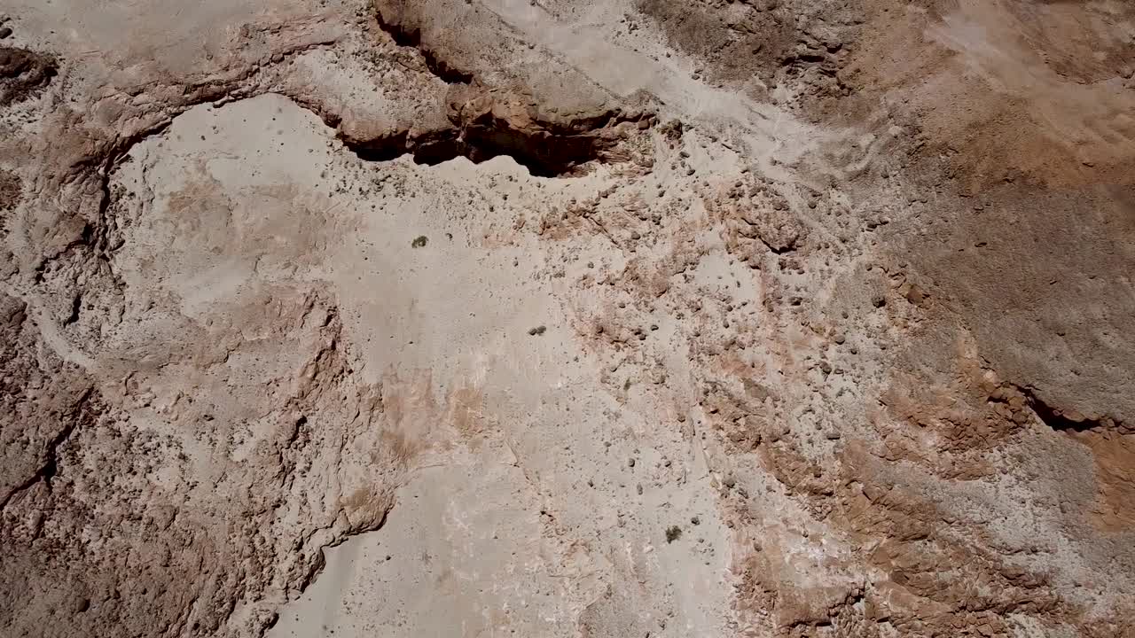 toma aérea lenta y calmante de un desierto vacío lleno de diferentes tonos y colores, montañas, colinas, crestas, rocas y arena
