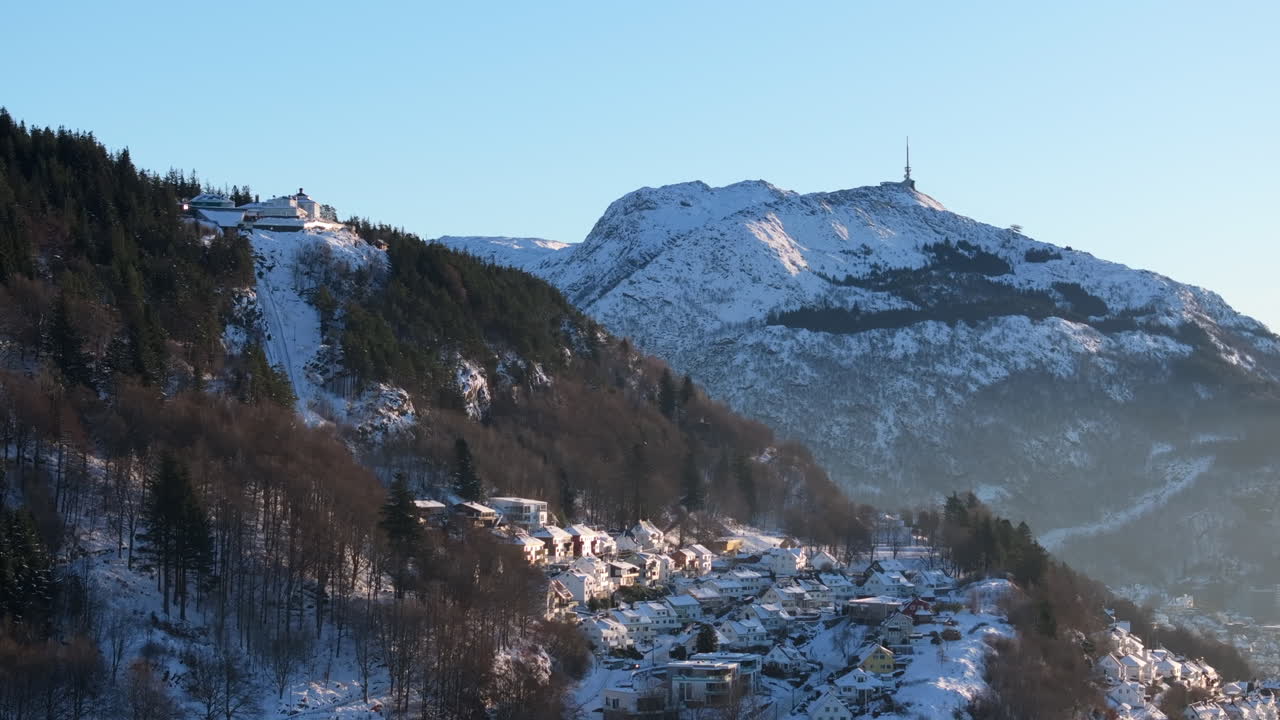Aerial shot of mount Fløyen and Ulriken covered in snow on a winter day in Bergen