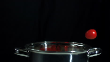 cherry tomatoes falling into saucepan