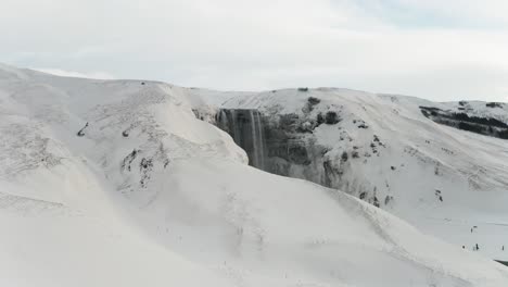 Ein-Wunderschöner-Großer-Wasserfall-In-Island-Mitten-Im-Winter,-Bedeckt-Von-Schnee-Und-Den-Wolken,-Macht-Es-Noch-Besser