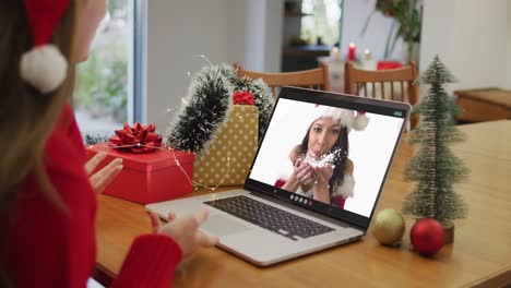 Happy-caucasian-woman-on-video-call-with-female-friend-at-christmas-time