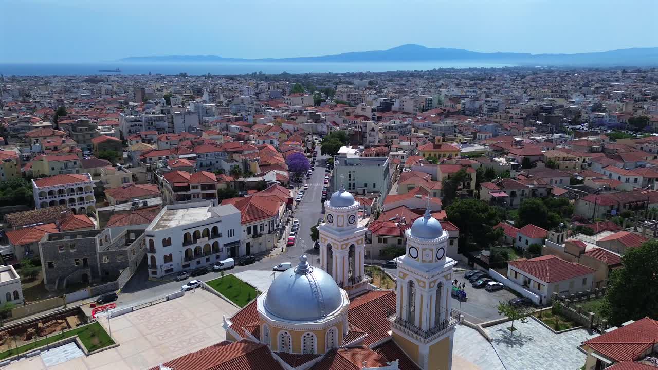 Aerial high view of Kalamata cityscape, orbital drone movement with famous metropolitan cathedral, Ypapanti church in the foreground. Panoramic view of the city, with Messinian bay on background