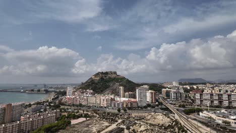 elevated view of alicante city, spain. fixed camera time lapse with a view of city center, castle and mediterranean sea. sunny summer day with some clouds in a changing sky. 4k