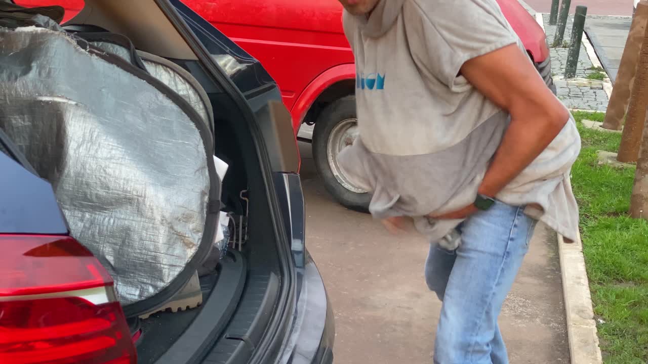 해변 앞 공원에서 잠수복을 입은 활동적인 젊은 남성 서퍼의 넓은 시야, 카스카이스