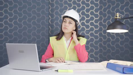 the woman engineer watching the construction is thoughtful.