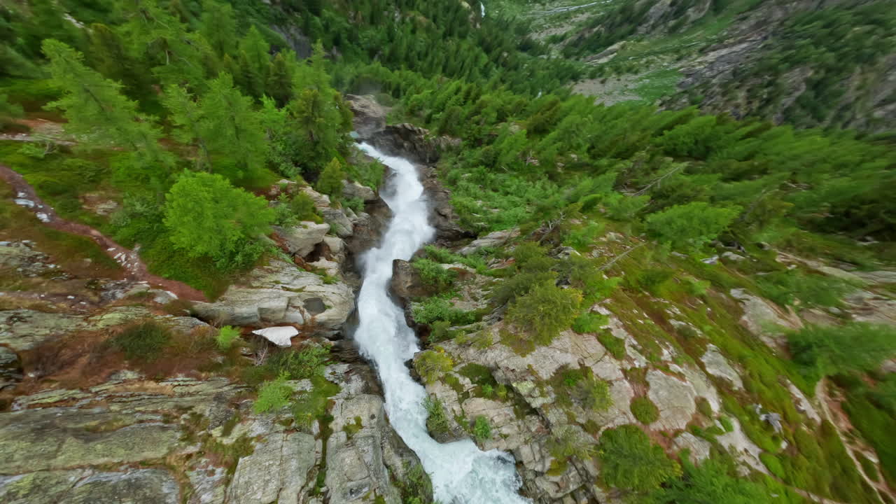hermoso paisaje alpino con cascadas en cascada y picos de montañas nevadas