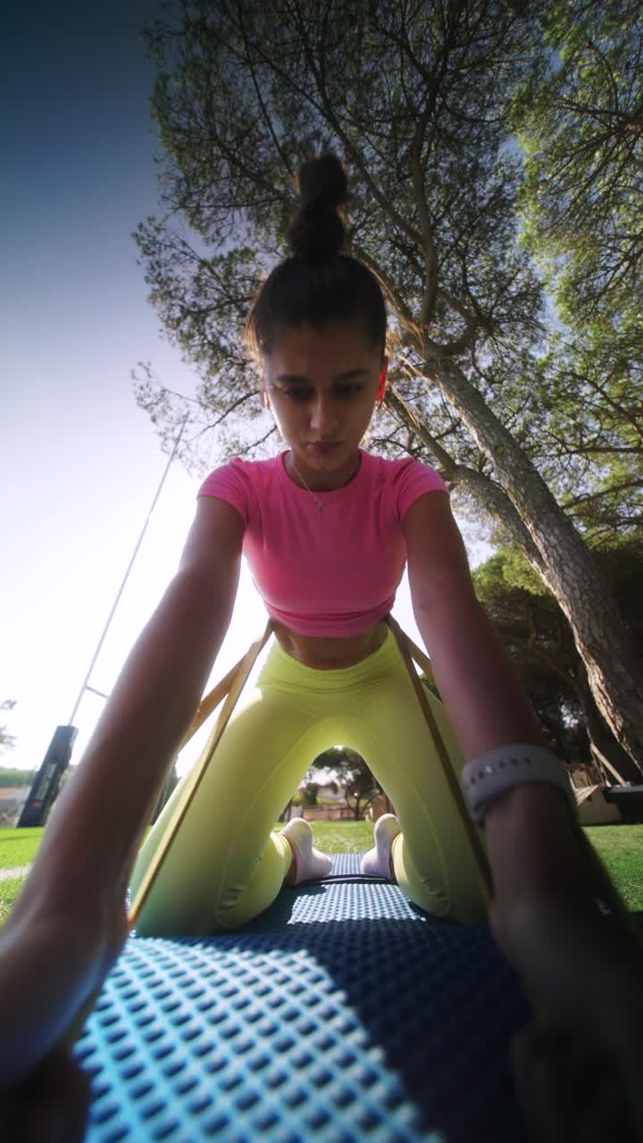 mulher a exercitar-se ao ar livre com uma banda de resistência