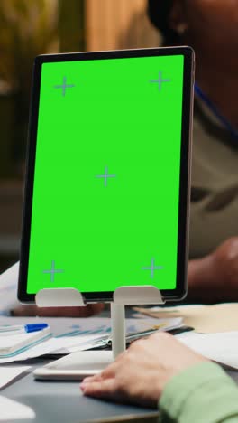 vertical video business colleagues meeting late in the office with green screen tablet