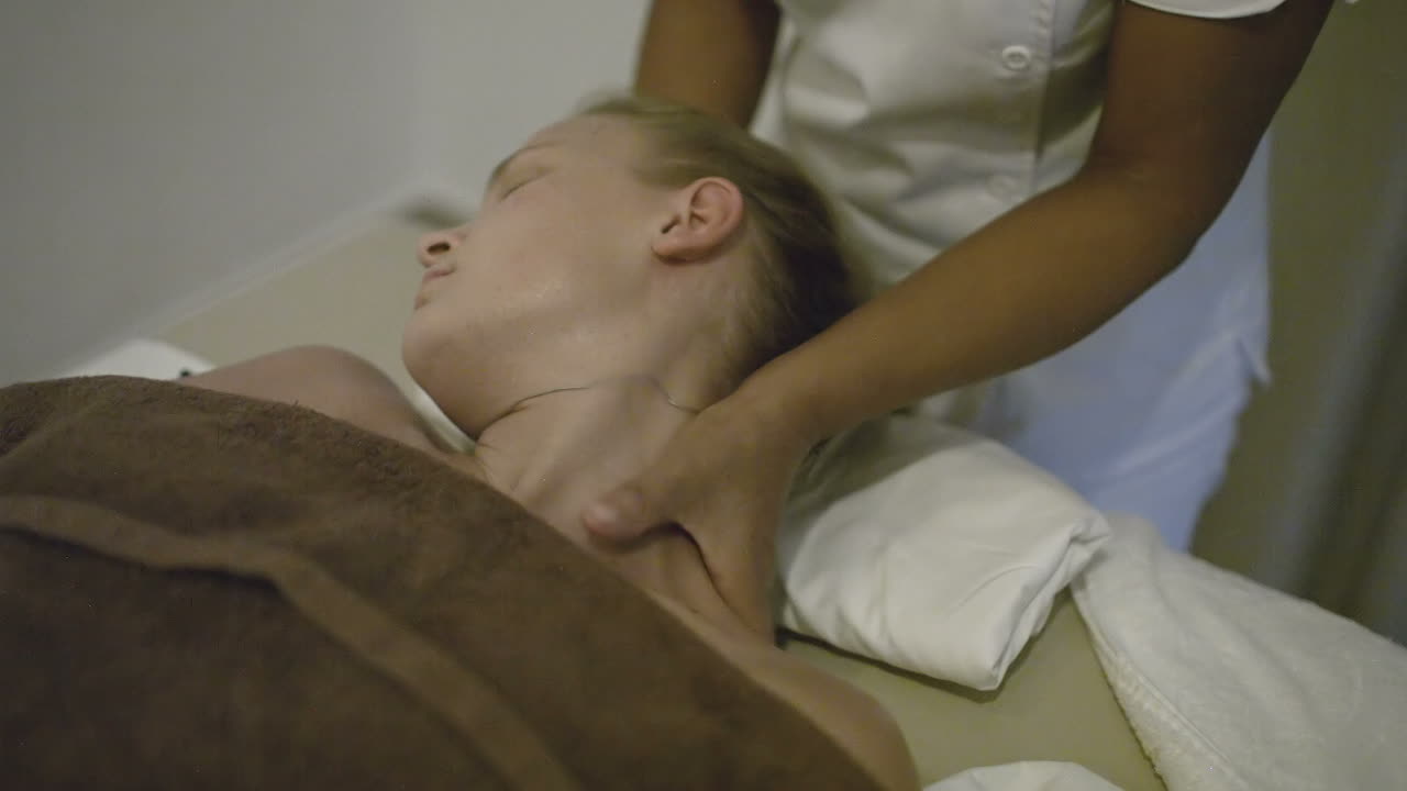 Ung kvinde får hovedmassage på spa