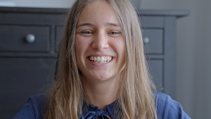 Happy cheerful woman smiling into camera, portrait close up view