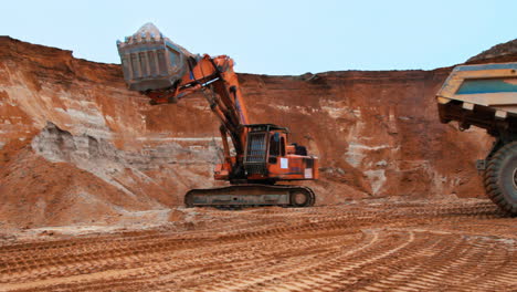 excavator loading sand into tipper truck. caterpillar excavator digging soil