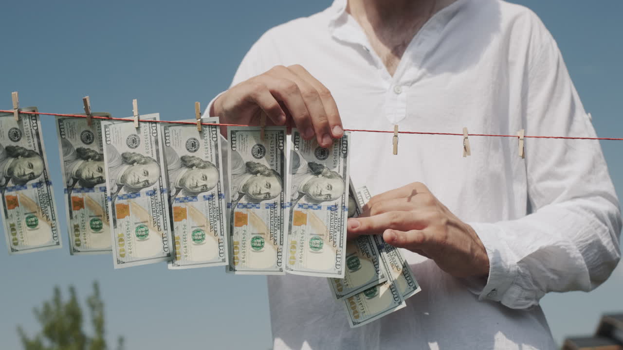 человек снимает банкноты с линии для белья. концепция отмывания денег