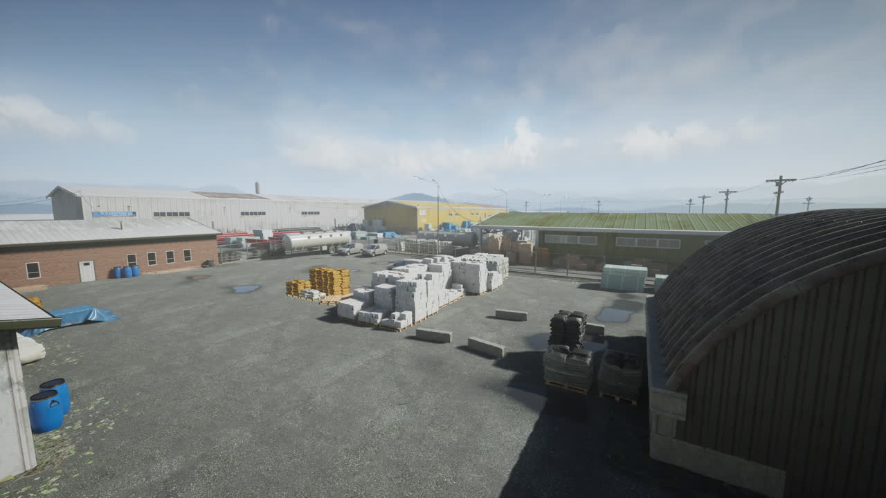 exterior de un edificio industrial con un gran patio lleno de paletas y contenedores de almacenamiento.