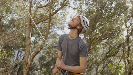 excursionista con cuerda de escalada en montañas de bosque denso durante la actividad al aire libre