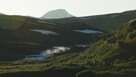 mountain stream flows down on stekenjokk fields, during sunset hour